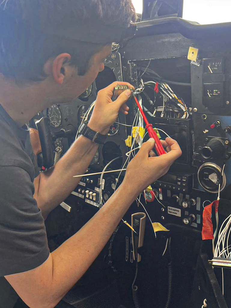 Avionik-Techniker bei der Verkabelung im Cockpit