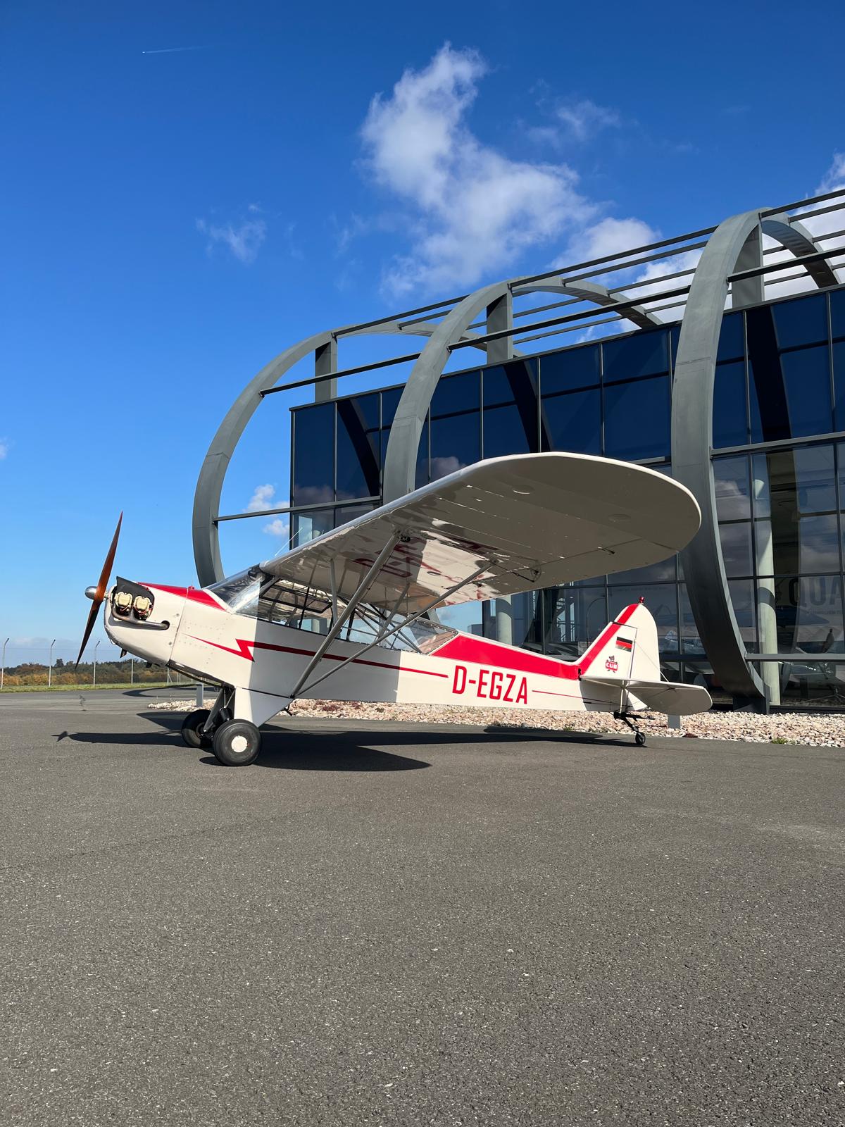 Piper J3C vor dem Quax Hangar auf dem Vorfeld